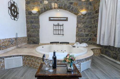 a bathroom with a tub with a stone wall at Shirat Hayam Boutique Hotel in Tiberias