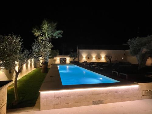 a swimming pool in a backyard at night at Masseria dei Monaci in Otranto