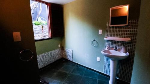 a bathroom with a sink and a window at Mística Pipa Hostel in Pipa