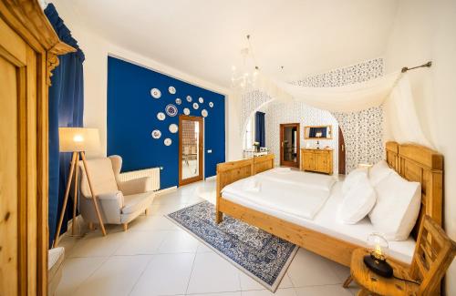チェスキー・クルムロフにあるPension Fortnaの青い壁のベッドルーム1室(大型ベッド1台付)