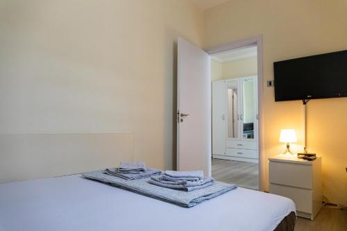 ein Schlafzimmer mit einem Bett und einem Fernseher an der Wand in der Unterkunft Dixy apartman in Belgrad