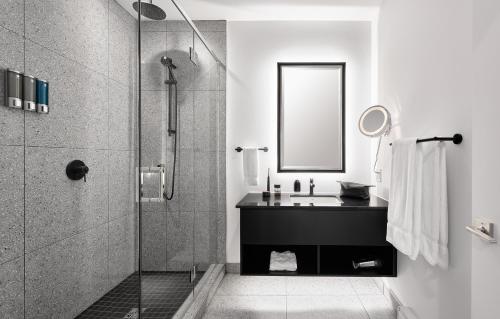 a bathroom with a sink and a shower at Les Lofts du Théâtre in Quebec City