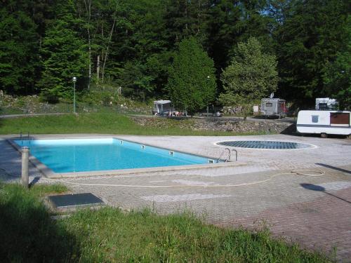 a swimming pool in a yard with a rv parked at Camping Pivka Jama Postojna in Postojna