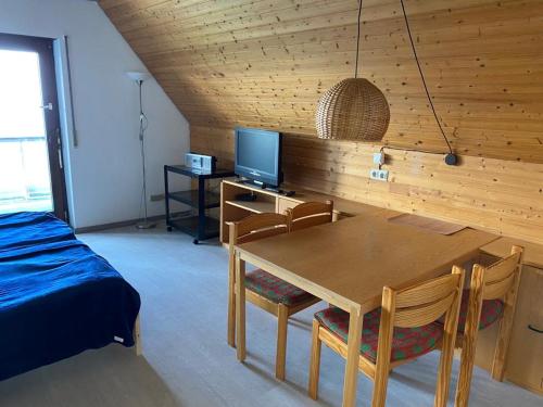 um quarto com uma mesa e cadeiras e uma televisão em Overpoint Panorama em Sasbachwalden