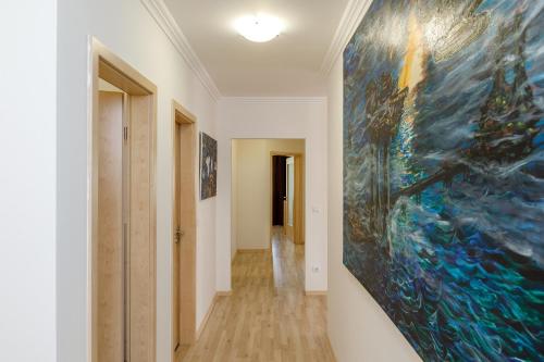 a hallway with a large painting on the wall at Andi Apartman in Hévíz