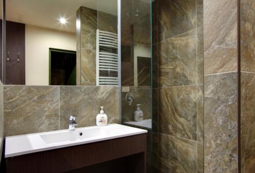 łazienka z umywalką i lustrem w obiekcie Corvin Apartman w mieście Gyula