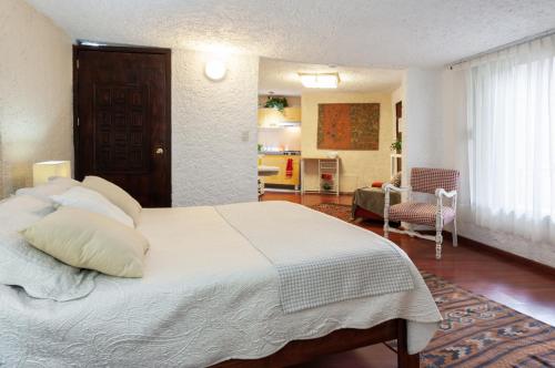 1 dormitorio con 1 cama blanca grande y cocina en Suite 2B, Vista, Garden House, Welcome to San Angel, en Ciudad de México