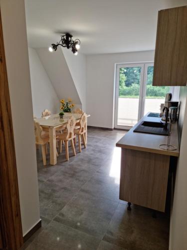 a kitchen and dining room with a table and chairs at Sylwia Aparthouse - Biały Dunajec in Biały Dunajec