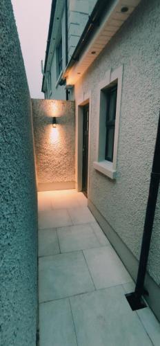 a hallway leading to a building with a light on it at Home Sweet Home in Ballycastle