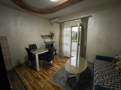 a living room with a table and chairs and a window at Apartment Zevs 1 in Budva