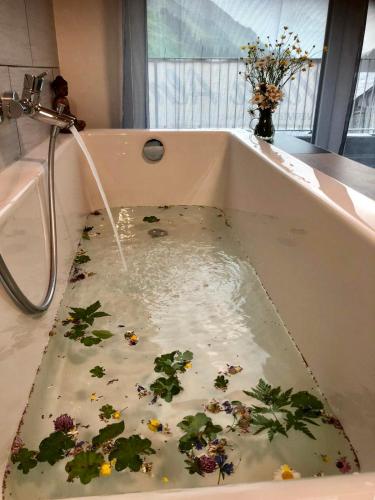 una bañera llena de agua con plantas. en Villa Alma Arlberg, en Warth am Arlberg
