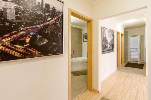 un couloir orné d'un tableau mural et une salle de bains. dans l'établissement Andi Apartman, à Hévíz