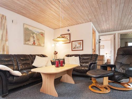 ブラーバンドにある6 person holiday home in Bl vandのリビングルーム(革製家具、テーブル付)