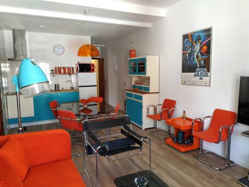 a living room with red chairs and a kitchen at La Encomienda de Almagro II in Almagro