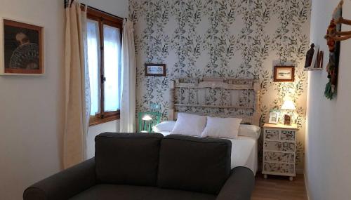 een slaapkamer met een bed en een bank bij La Encomienda de Almagro II in Almagro