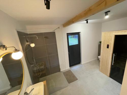 ein Bad mit einer Dusche und einer Glasduschkabine in der Unterkunft Na Kaszubskim Wzgórzu z sauną i banią in Garcz