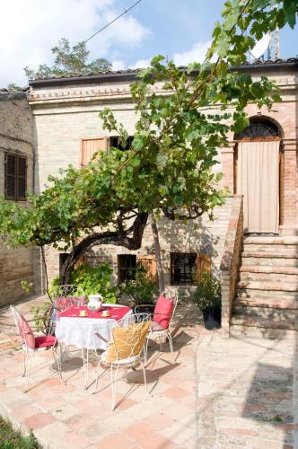 a patio with a table and chairs in front of a building at B&B La Cappellania in Montegiorgio