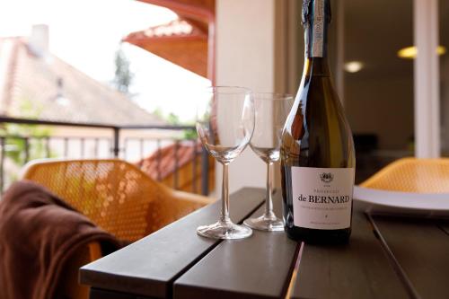 a bottle of wine and two glasses on a table at Andi Apartman in Hévíz