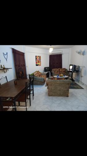 a living room with a couch and a table at Cozy sunny ground chalet with terrace-Ras Sudr in Ras Sedr