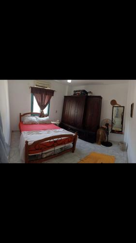 a bedroom with a large bed with a wooden headboard at Cozy sunny ground chalet with terrace-Ras Sudr in Ras Sedr