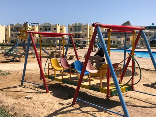 a swing set at a playground at a resort at Cozy sunny ground chalet with terrace-Ras Sudr in Ras Sedr