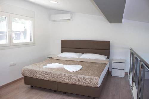 a bedroom with a bed with two towels on it at IL-Holidays Paralia in Paralia Katerinis