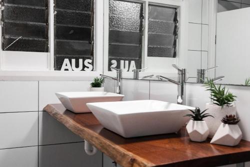 two sinks on a wooden counter in a bathroom at Mad Monkey Central in Cairns