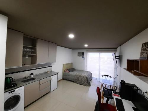 um quarto com uma cama e uma cozinha com um lavatório em Monoambiente céntrico em Posadas