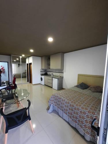 Monoambiente céntrico في بوساداس: غرفة نوم بسرير وطاولة زجاجية
