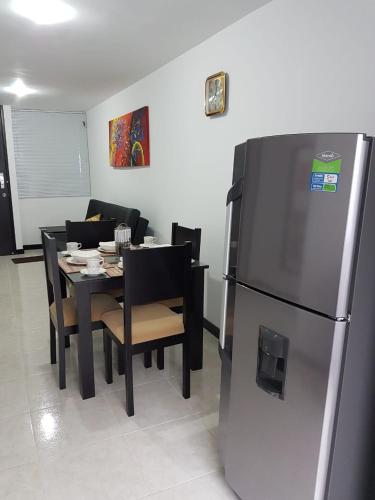 a kitchen and dining room with a table and a refrigerator at Economico Apto a 3' al Parque del Café in Quimbaya