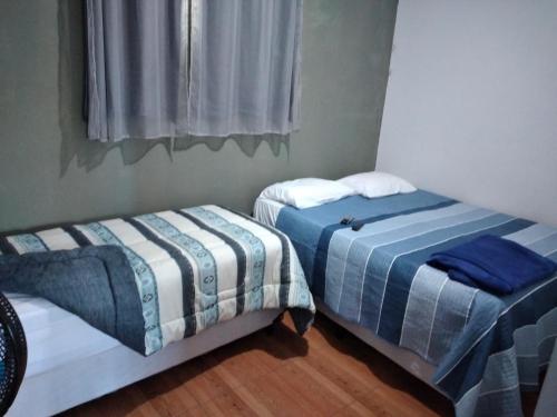 twee bedden naast elkaar in een kamer bij KITNET'S DA DENI in Alto Paraíso de Goiás