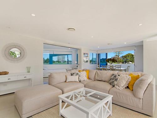 
a living room filled with furniture and a large window at Neilson on the Park Unit 1A - Easy walk to beaches, cafes and shopping in Coolangatta in Coolangatta
