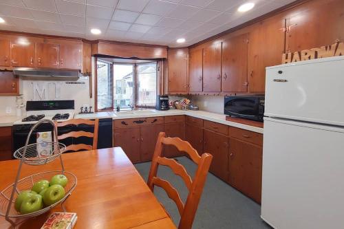 a kitchen with a wooden table and a white refrigerator at Huge historic, w/large yard & close to beach in Manistee