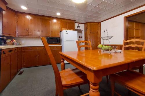 a kitchen with a wooden table with chairs and a refrigerator at Huge historic, w/large yard & close to beach in Manistee