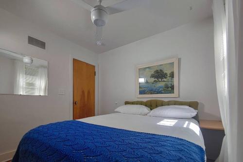 a bedroom with a large bed with a blue blanket at Huge historic, w/large yard & close to beach in Manistee