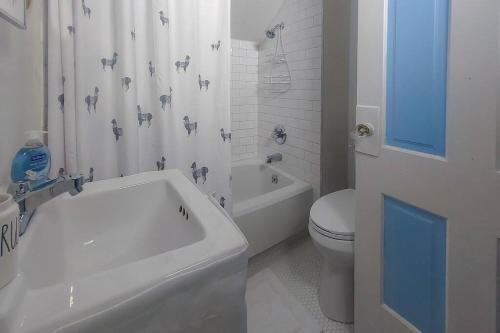 y baño con bañera, aseo y lavamanos. en Historic w/deck, king bed & air by Lake Michigan en Manistee