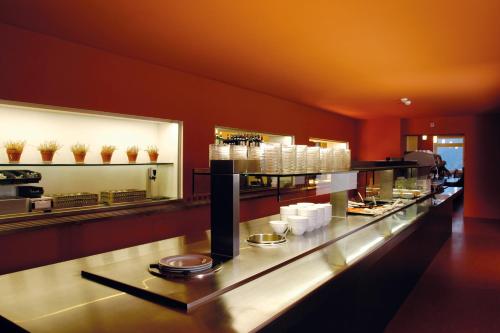 a restaurant with a long counter with dishes at Davos Youth Hostel in Davos