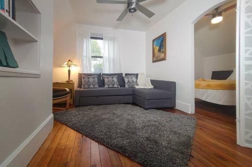 a living room with a blue couch and a bed at Historic w/deck, king bed & air by Lake Michigan in Manistee