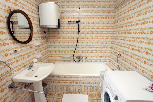a bathroom with a tub and a sink and a mirror at Portoroz Vintage Apartment with Amazing Sea View MO in Portorož