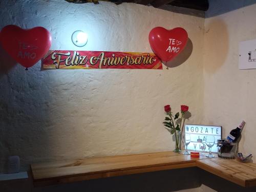 a table with two hearts and a vase with roses at Mirador Valle del Tomine - Cabaña vista al embalse in Guatavita