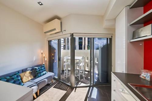eine Küche und ein Wohnzimmer mit Sofa und Tisch in der Unterkunft ReadySet Apartments at Kett in Melbourne