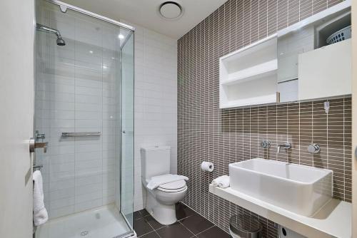 ein Badezimmer mit Toilette, Waschbecken und Dusche in der Unterkunft ReadySet Apartments at Kett in Melbourne