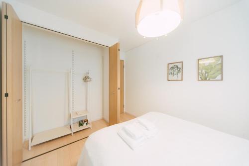 a bedroom with a white bed and a large mirror at Plage in Yamada