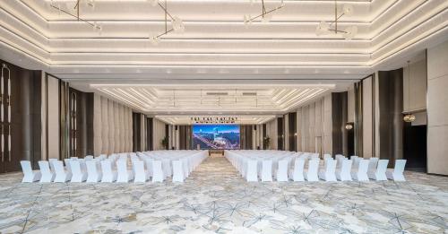 a row of white chairs in a room with a ballroom at Grand Bay Hotel Chengdu in Chengdu