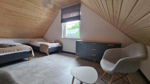 - une chambre avec un lit, une chaise et une fenêtre dans l'établissement Przystań pod Witoszą, à Staniszów