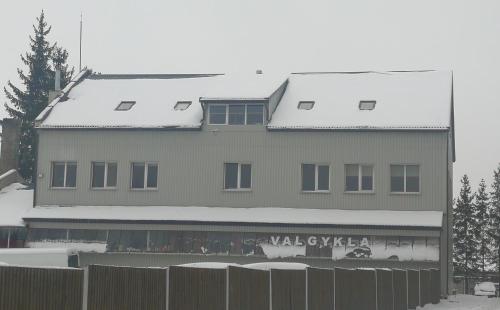 un bâtiment avec une clôture devant lui dans l'établissement Viešbutis Kelyje, à Utena