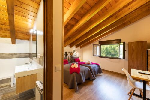 ein Schlafzimmer mit zwei Betten in einem Zimmer mit Holzdecken in der Unterkunft LA PANDELA in Las Herrerías
