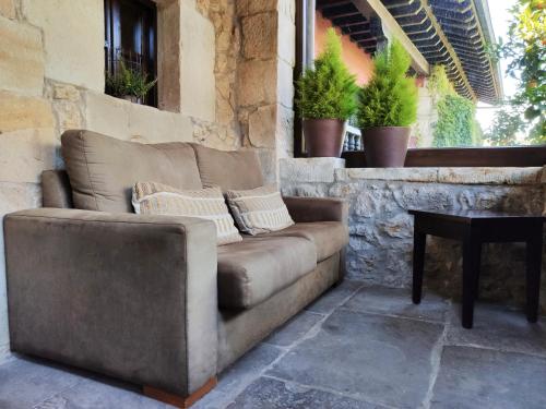 a couch sitting on a patio with a table at Hotel Casa del Marqués in Santillana del Mar