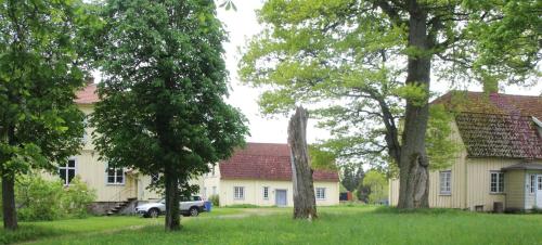 a car parked in front of a house with trees at Yxkullsund Säteri B&B - Manor & Estate since 1662 in Lagan
