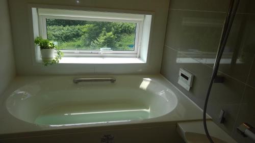 a bath tub in a bathroom with a window at KEI in Lake Toya